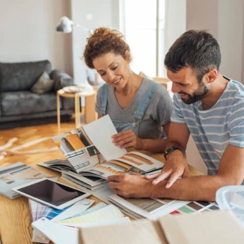 home improvement contractors Two young homeowners discussing the best options for different home renovation projects while looking at potential designs.