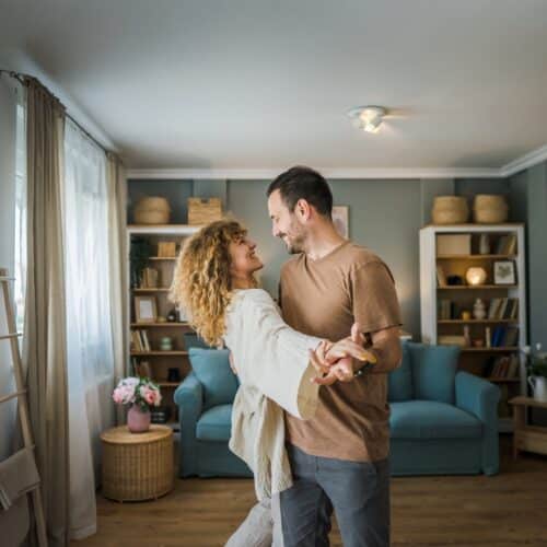 home improvement contractors A man and a woman are dancing in the middle of their living room. In the background are bookshelves and furniture.