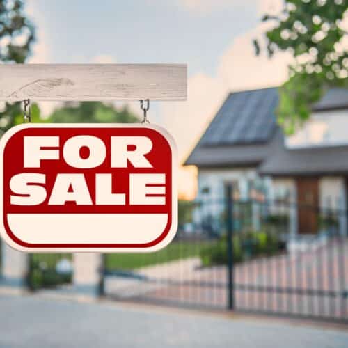 home improvement contractors Red for sale sign displayed in front of a well-maintained residential home.